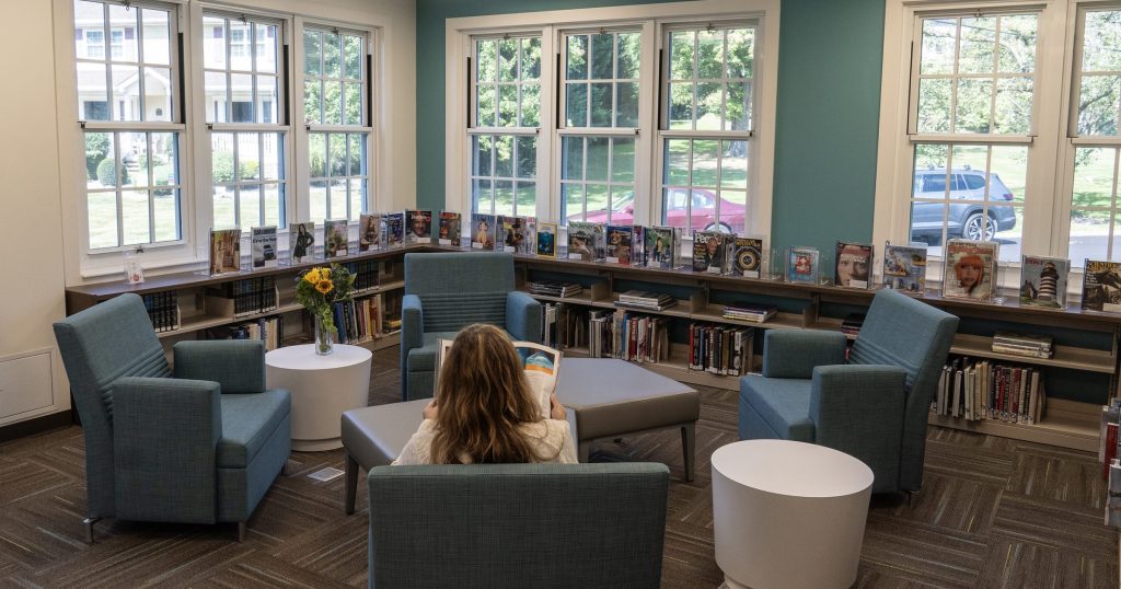 Woman sitting in chair reading at Fanwood Memorial Library.